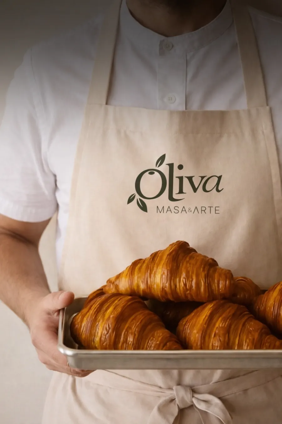 Delantal beige de Oliva y bandeja de croissants.